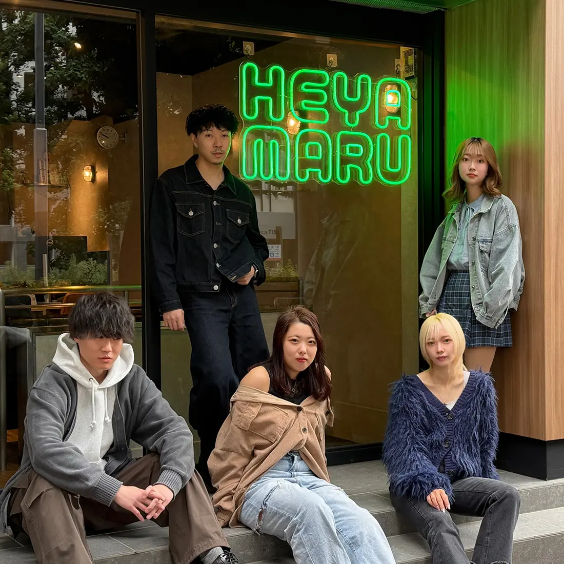 HEYAMARU店舗前で座る若い男女グループ