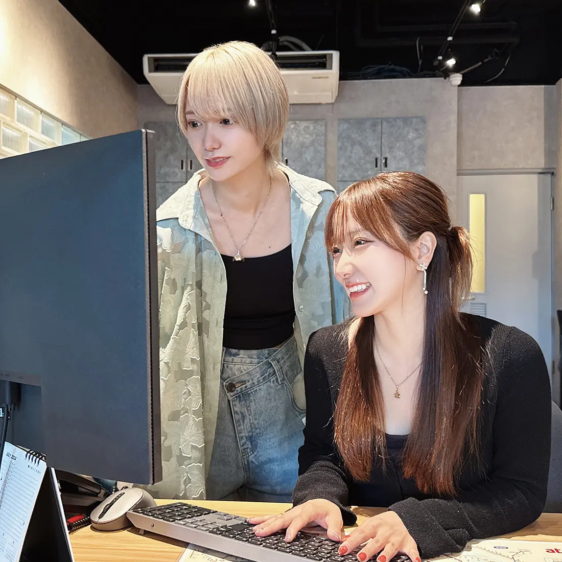 2人の女性スタッフがパソコンでSNS運用を行っている様子